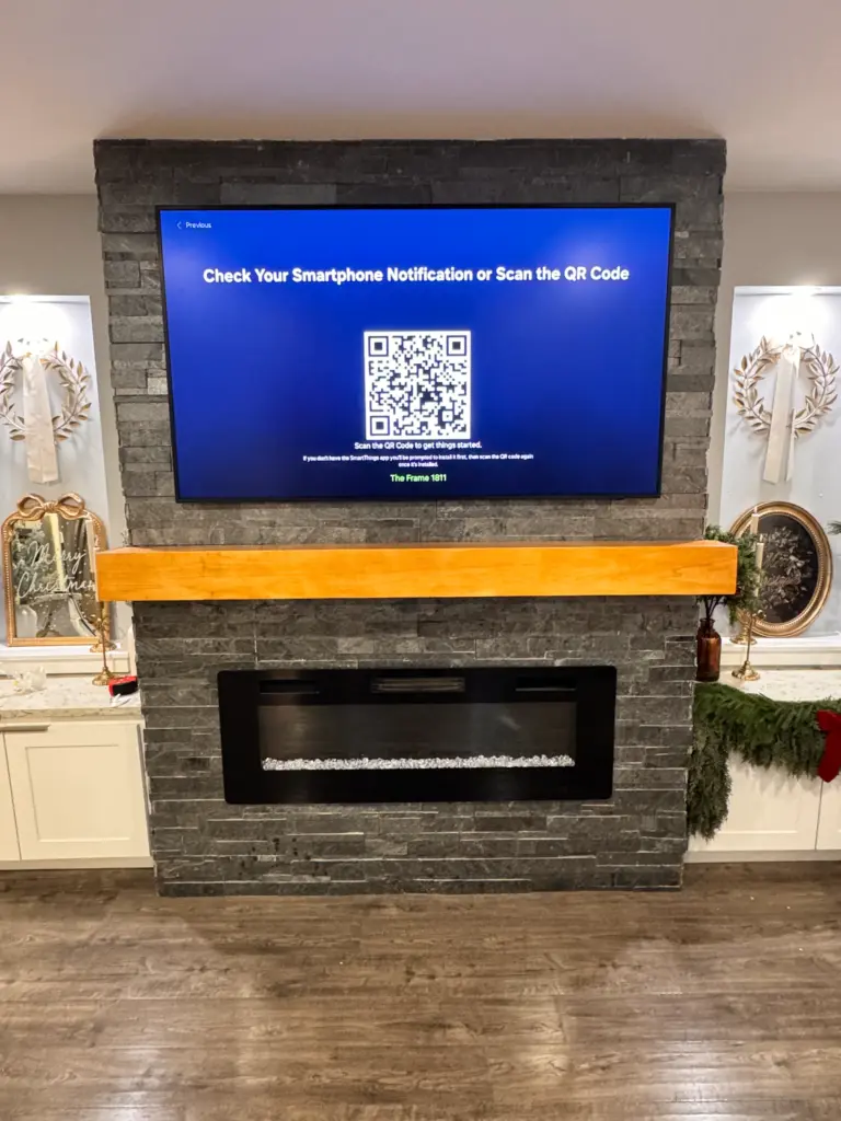 TV mounted above a dark stacked stone fireplace with a natural wood mantle in a modern living room.