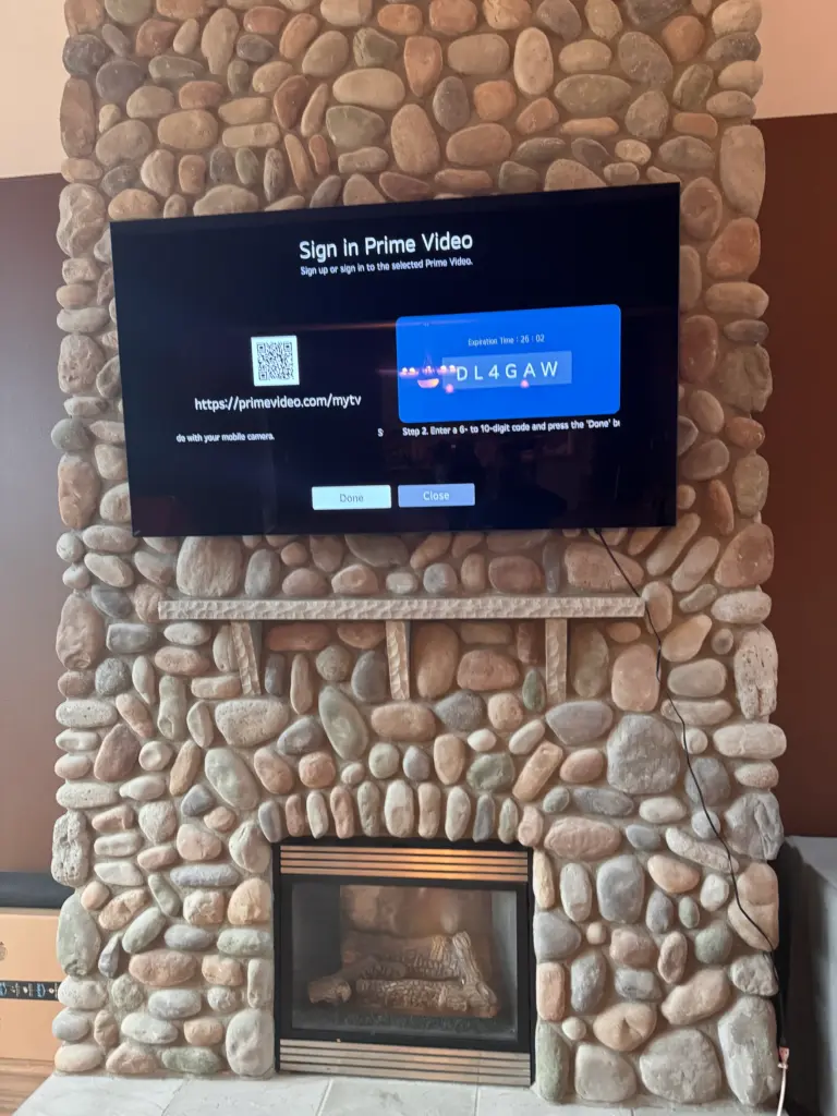 TV mounted above a river rock fireplace with visible wire setup during installation in Washington.