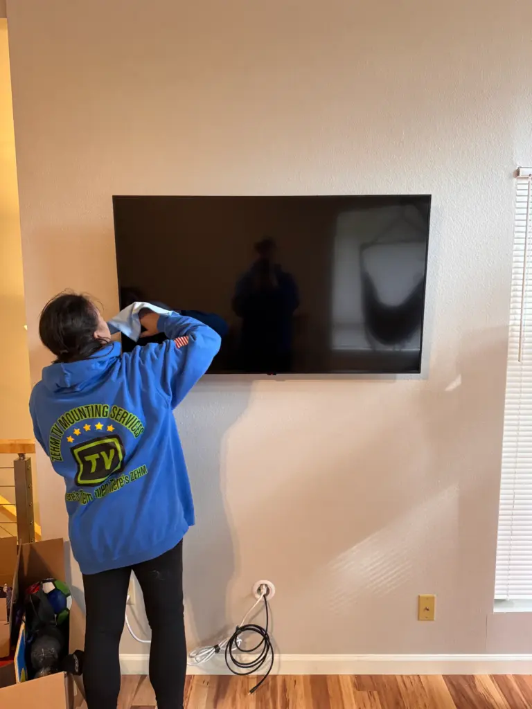 Jenae Zehm mounting a TV for a customer in Tacoma Washington as part of a professional TV installation by ZehmTV Mounting Services.